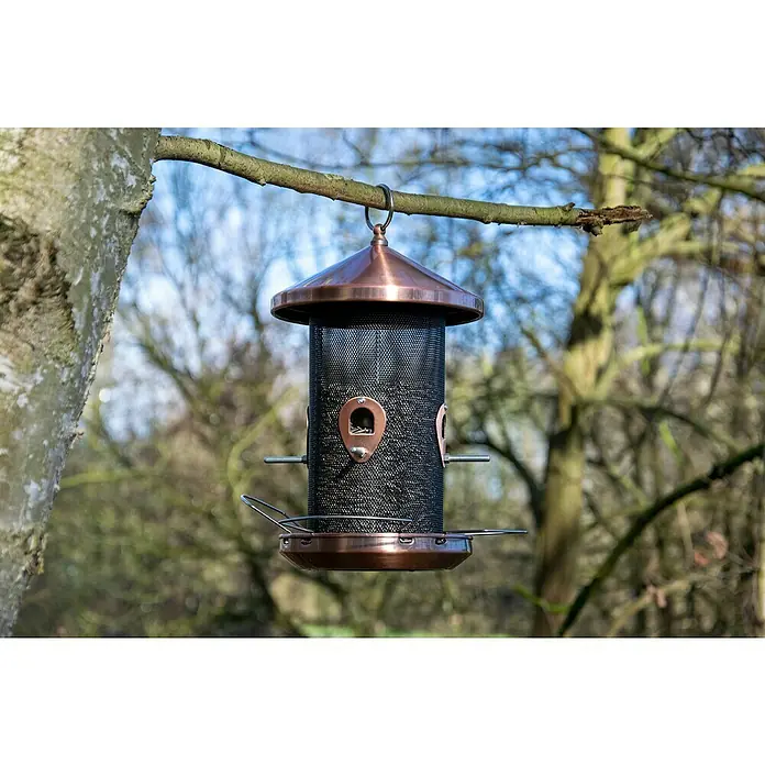 Dobar Futterspender - Material: Metall, Mit Silo - Eine hängende Vogeltränke mit kupferfarbenem Dach und Boden, die an einem Ast im Freien befestigt ist, um Vögel anzulocken.