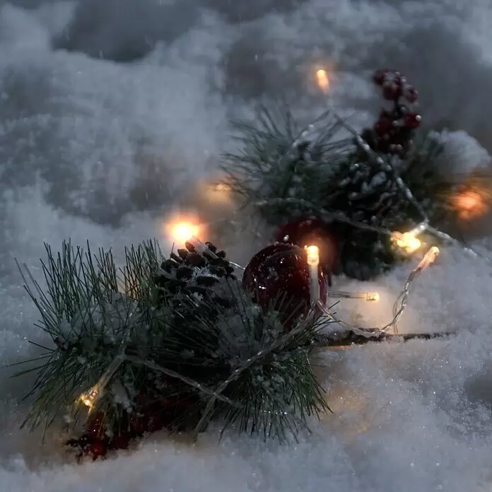 Konstsmide LED-Lichterkette - Außen, Lichtfarbe: Warmweiß, Anzahl Leuchtmittel: 80 Stk., Batteriebetrieben, Weiß - Weihnachtsdekoration mit Tannenzweigen, Tannenzapfen, roten Beeren und warmen Lichterketten im Schnee.