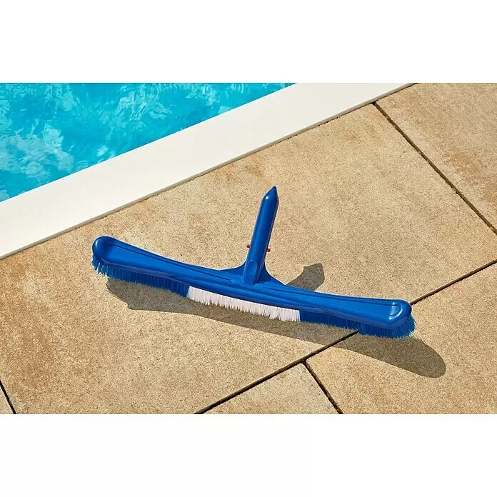 Malibu Poolbürste Ocean - Kunststoff, Blau - Eine blaue Poolbürste mit weißen und blauen Borsten liegt auf den hellen Pflastersteinen neben einem Schwimmbecken.