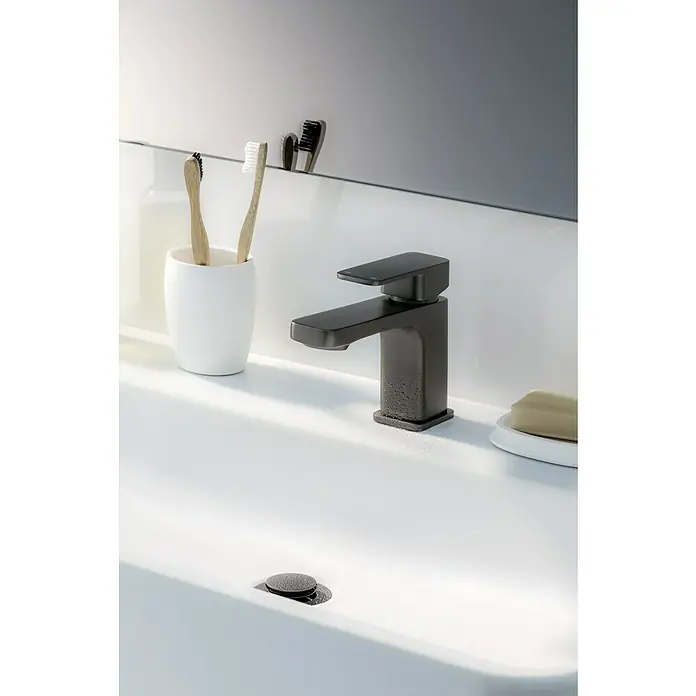 Camargue Waschtischarmatur Marbella - Graphit, Matt - Eine Nahaufnahme einer eleganten, mattschwarzen Waschtischarmatur auf einem weißen Waschbecken mit Zahnbürsten und Seife.