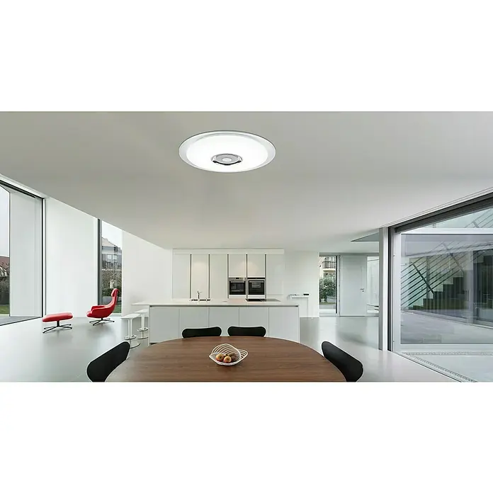 Globo LED-Deckenleuchte rund Tune - 36 W, Ø x H: 600 mm x 6,1 cm, Weiß, Opal, RGB - Das Bild zeigt eine moderne Deckenleuchte mit integriertem Lautsprecher in einem minimalistischen Raum mit Küche und Essbereich.