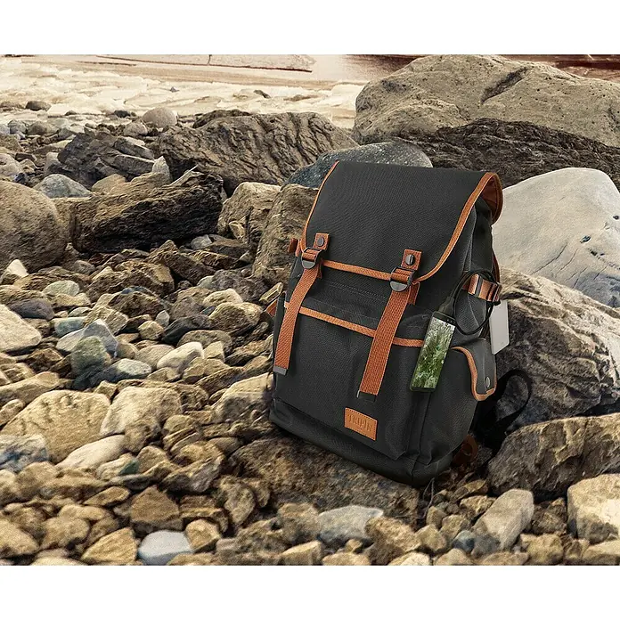 T'nB Cable USB - Largo: 60 cm - Una mochila negra con detalles marrones sobre una superficie rocosa, ideal para aventuras al aire libre y viajes elegantes.