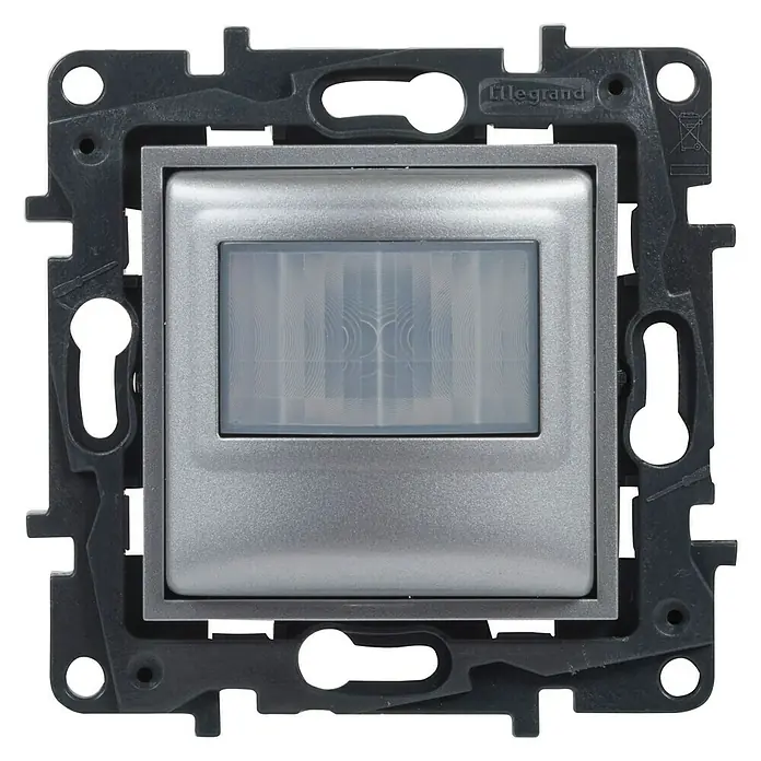 Legrand Niloé Step Mecanismo detector de movimiento - Aluminio, Mate, Montaje en la pared - Detector de movimiento Legrand para montaje en pared. El sensor es cuadrado y de color plateado, rodeado por un marco negro con orificios de montaje.