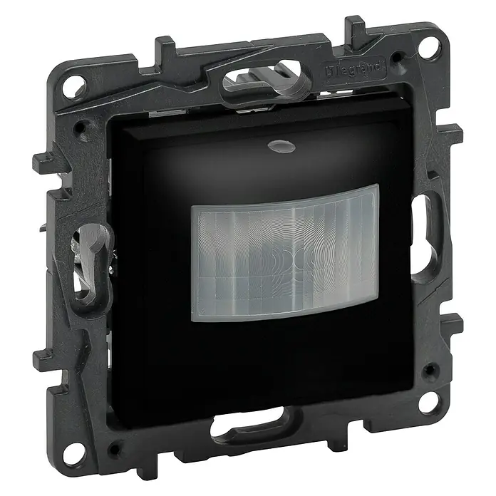 Legrand Niloé Step Mecanismo detector de movimiento - Antracita, Mate, Montaje en la pared - Primer plano de un sensor de movimiento Legrand negro, insertado en un marco de montaje gris con orificios de fijación y el logo de Legrand en la parte superior derecha.