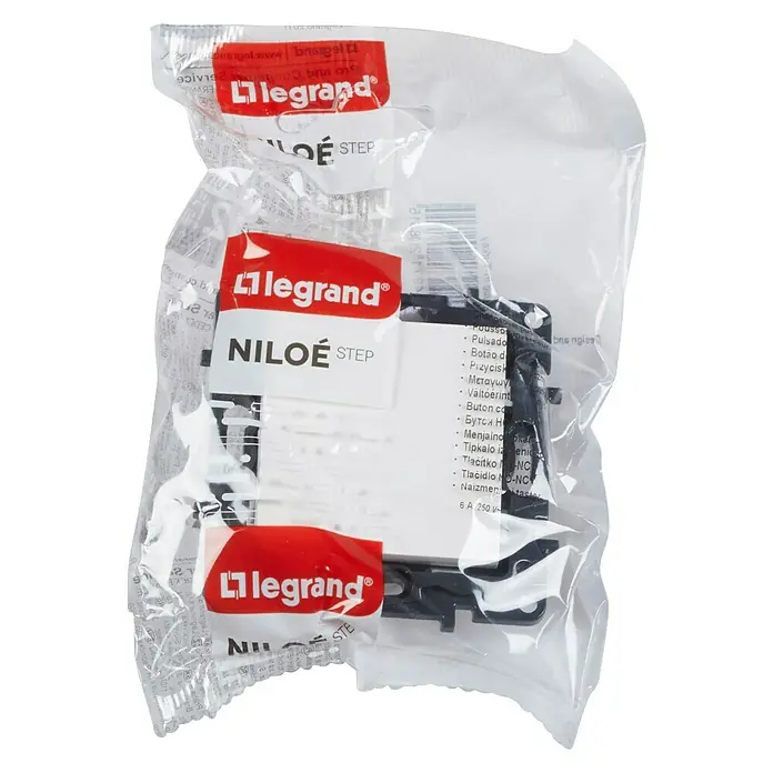 Legrand Niloé Step Pulsador para estancias con humedad - Blanco, Montaje en la pared - Primer plano de un pulsador Legrand Niloe Step en un embalaje transparente, mostrando detalles del producto y el logotipo de la marca.