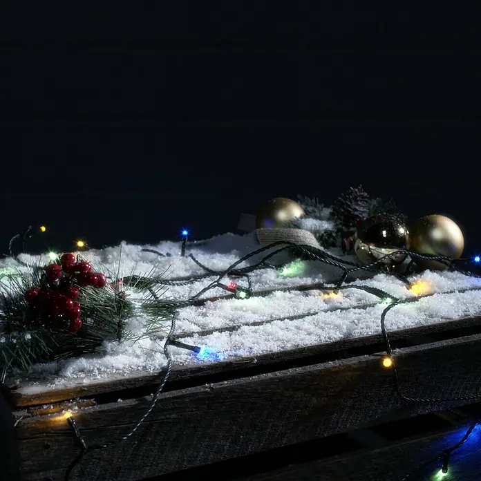 Tween Light Guirnalda luminosa LED - Para exterior, Color de luz: RGB, Número de bombillas: 200 ud., Funcionamiento en red - Decoración festiva con bolas doradas, frutos rojos y luces en una caja de madera nevada para crear un ambiente navideño acogedor.