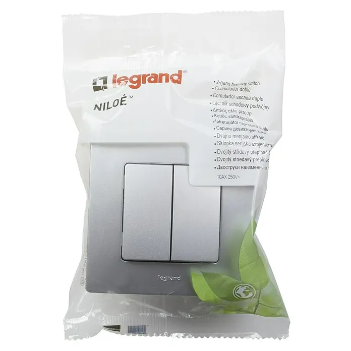 Conmutador doble Niloé Monoblock - Plateado, Montaje en la pared - Primer plano de un interruptor de dos vías Legrand Niloe en un embalaje transparente, listo para instalar.