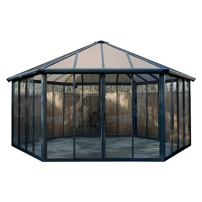 Palram – Canopia Pérgola de jardín cerrado Garda - L x An x Al: 5,95 x 5,17 x 3,13 m, Aluminio, Gris - Un cenador moderno con paredes transparentes y un techo protector sobre una superficie plana.