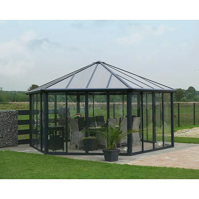 Palram – Canopia Pérgola de jardín cerrado Garda - L x An x Al: 5,95 x 5,17 x 3,13 m, Aluminio, Gris - Esta imagen muestra una elegante glorieta exenta con paredes de vidrio transparente, situada invitando en un entorno de jardín, ofreciendo protección y estilo.
