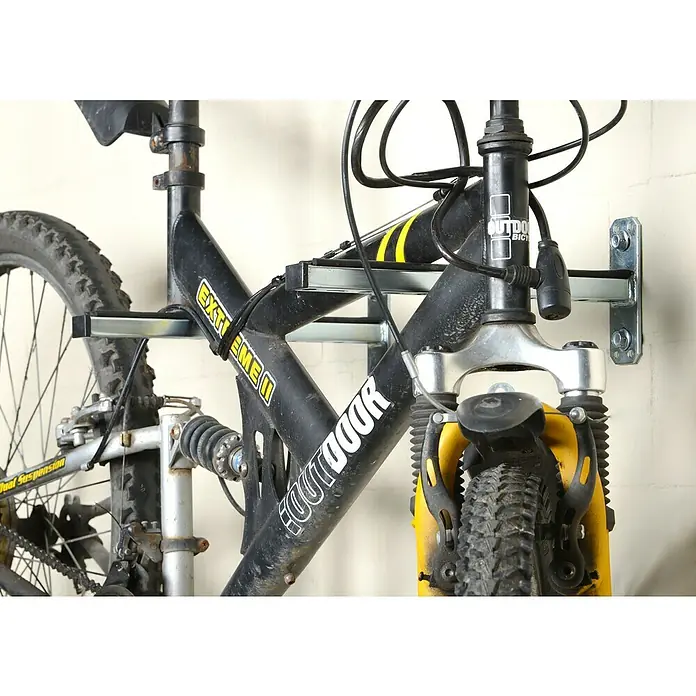 UBB Schienenkonsole - Profil: 38/40, Länge: 440 mm - Nahaufnahme eines an einer Wand montierten Fahrradträgers mit einem schwarzen Outdoor-Fahrrad.