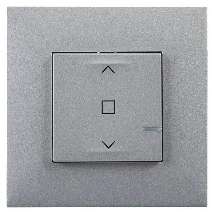 Legrand Valena Next with Netatmo Interruptores para persianas - Aluminio, Montaje en la pared - Primer plano de un interruptor de persiana plateado con símbolos de flecha arriba, cuadrado y flecha abajo. Diseño moderno para domótica.