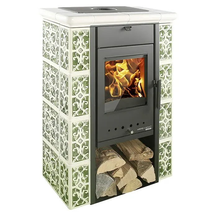 Haas+Sohn Kaminofen Tirol - 6 kW, Raumheizvermögen: 140 m³, Material Verkleidung: Keramik, Grün/Weiß - Nahaufnahme eines Haas+Sohn Kaminofens mit grünen Kacheln, Feuer und Holzscheiten, der Wärme und Eleganz vereint.