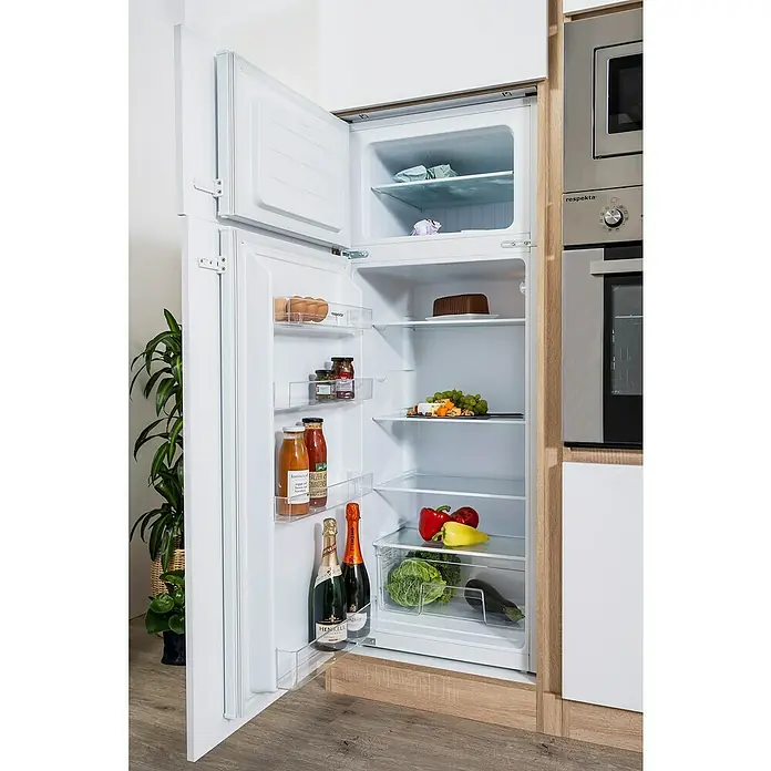 Respekta Premium Küchenzeile Lorena - Breite: 445 cm, Weiß, Hochglänzend, Dekor Arbeitsplatte: Holzoptik, Mit Elektrogeräten - Ein offener Kühlschrank, der eine Vielzahl von Lebensmitteln enthält, darunter Eier, Getränke, Gemüse und sogar eine Torte.