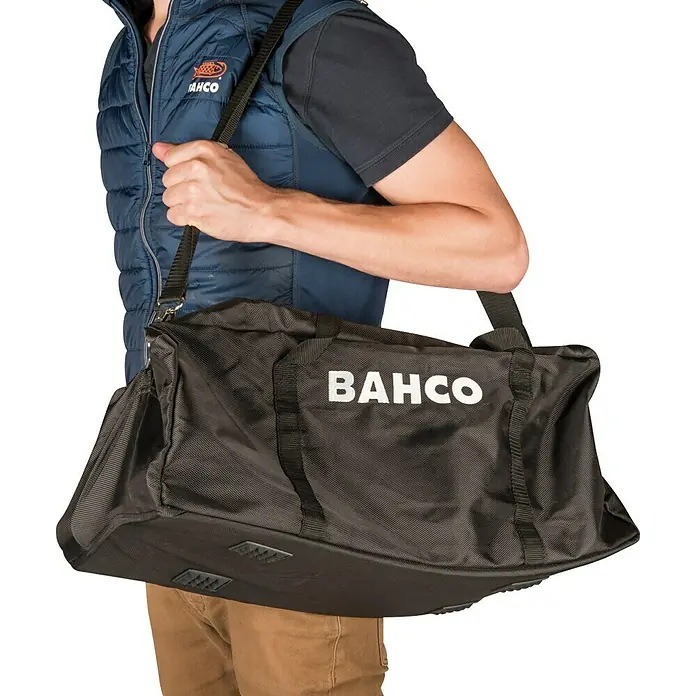 Bahco Hydraulischer Rangierwagenheber - Hubhöhe: 85 mm - 415 mm - Eine schwarze Werkzeugtasche von BAHCO wird von einer Person über der Schulter getragen. Ideal für Handwerker und Heimwerker.