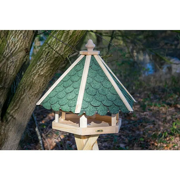 Dobar Vogelhaus - Grün/Braun - Ein detailreiches Foto eines hölzernen Vogelhauses mit grünem Dach und dekorativen Elementen im Freien.