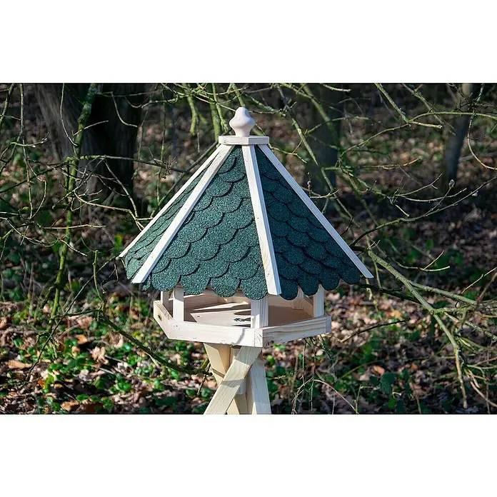 Dobar Vogelhaus - Grün/Braun - Nahaufnahme eines hölzernen Vogelhauses mit grünen Schindeln und einem dekorativen Turm, das auf einem Ständer inmitten der Natur steht.