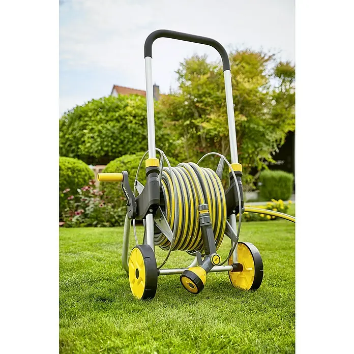 Neptun Kit carro portamangueras - Metal, Longitud del tubo: 30 m - El carro portamangueras NEPTUN está enrollado con una manguera y cuenta con una boquilla rociadora. Se encuentra en un césped en el jardín.