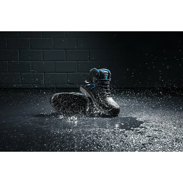 Power Safe Sicherheitshalbschuh Tom - Schuhgröße: 46, S3 - Abgebildet ist ein Paar wasserdichte, schwarze und blaue Arbeitsstiefel mit Schnürung, die im Wasser stehen und spritzen.
