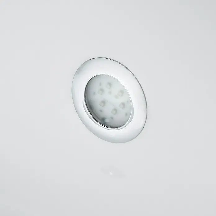 Ottofond Whirlpool Palermo - 190 x 90 cm, Sanitäracryl, Weiß, Inklusive Ab- und Überlaufgarnitur mit Wassereinlauf und Wannenrandarmatur S2000 - Nahaufnahme einer runden LED-Einbauleuchte mit Chromfassung in einer weißen Oberfläche, ideal für moderne Beleuchtungskonzepte.