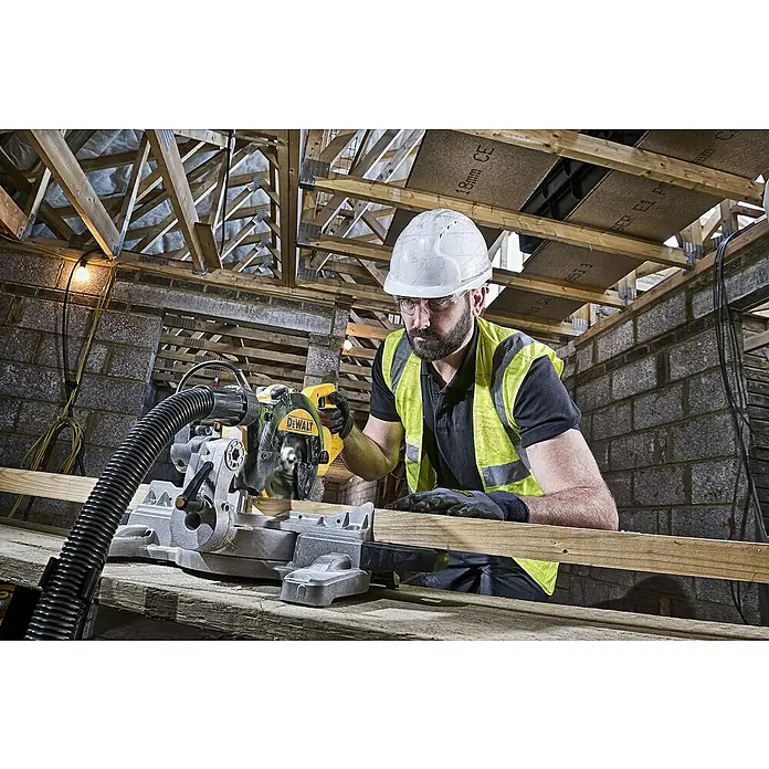 DeWalt Sierra ingletadora telescópica DWS774 - 1.400 W, 4.500 r.p.m., Diámetro hoja de sierra: 216 mm - Un trabajador de la construcción usa una sierra de inglete DEWALT para cortar madera. Trabajo de construcción seguro con herramientas DEWALT.