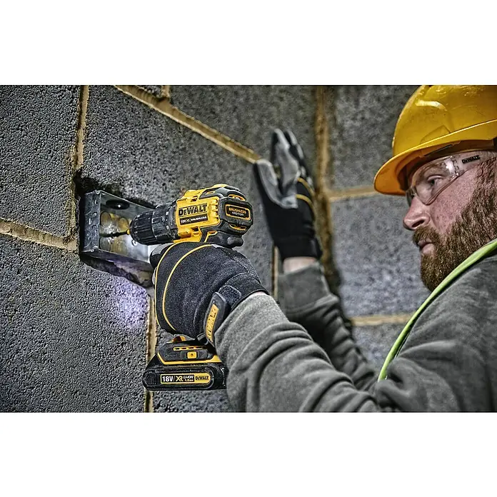 DeWalt XR 18V Akku-Bohrschrauber DCD708L2T - 18 V, 2 Akkus, 3 Ah, 65 Nm - Ein Bauarbeiter befestigt eine Metallbox mit einem gelben DeWalt 18V Akku-Bohrschrauber an einer Wand.