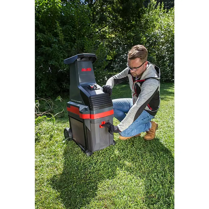 AL-KO Easy Crush Elektro-Walzenhäcksler LH 2810 - Max. Aststärke: 4,2 cm, 2.800 W - Ein Mann benutzt einen AL-KO Easy Crush LH 2810 Gartenhäcksler im Garten, um Gartenabfälle zu zerkleinern und zu kompostieren.