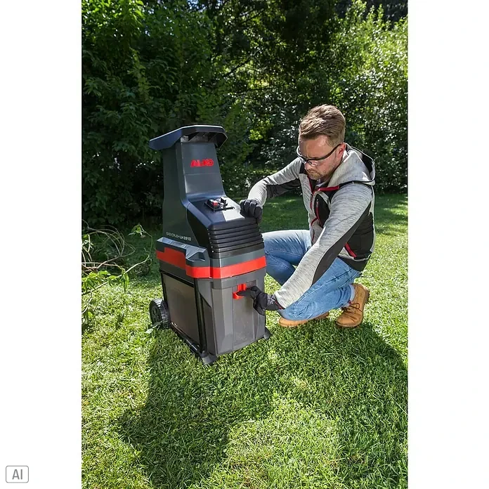 AL-KO Easy Crush Elektro-Walzenhäcksler LH 2810 - Max. Aststärke: 4,2 cm, 2.800 W - Ein Mann benutzt einen AL-KO Easy Crush LH 2810 Gartenhäcksler im Garten, um Gartenabfälle zu zerkleinern und zu kompostieren.