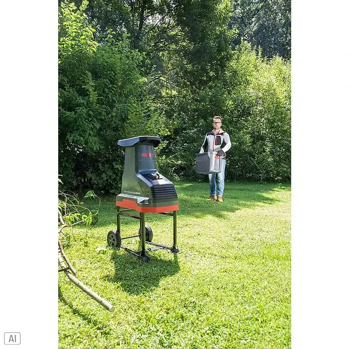 AL-KO Easy Crush Elektro-Walzenhäcksler LH 2810 - Max. Aststärke: 4,2 cm, 2.800 W - Der AL-KO Easy Crush LH 2810 Häcksler steht auf dem Rasen, während ein Mann den Auffangbehälter hält.