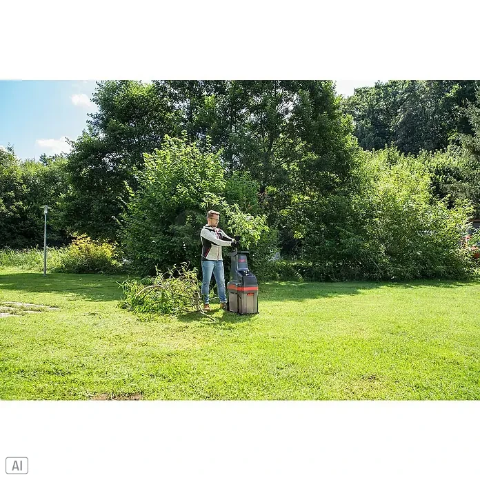 AL-KO Easy Crush Elektro-Walzenhäcksler LH 2810 - Max. Aststärke: 4,2 cm, 2.800 W - Ein Mann benutzt einen Gartenschredder im Freien, um Äste zu zerkleinern. Der Schredder ist rot und grau.