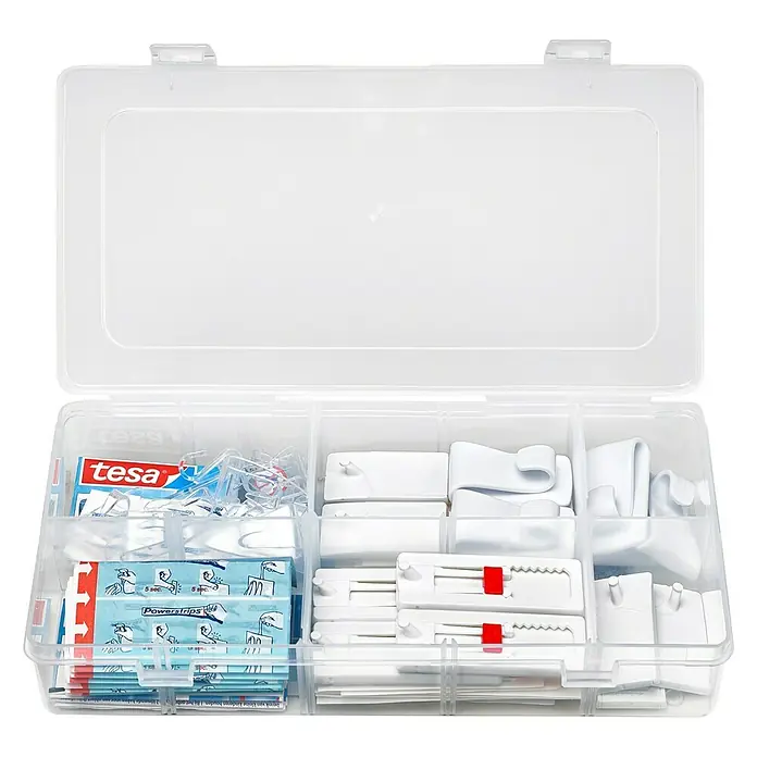 Tesa Befestigungs-Set Smart Mounting Box - Geeignet für: Glas - Eine durchsichtige Aufbewahrungsbox, gefüllt mit verschiedenen Tesa-Produkten, darunter Powerstrips und Klebehaken für die Wandmontage.