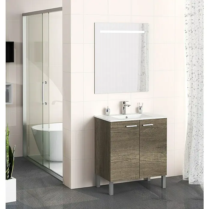 Artysan Mueble bajo de lavabo Fran - An x Pr x Al: 70 x 46 x 85 cm, Nebraska - Escena de baño con un moderno mueble de lavabo con aspecto de madera, un espejo con iluminación integrada y una cabina de ducha al fondo.