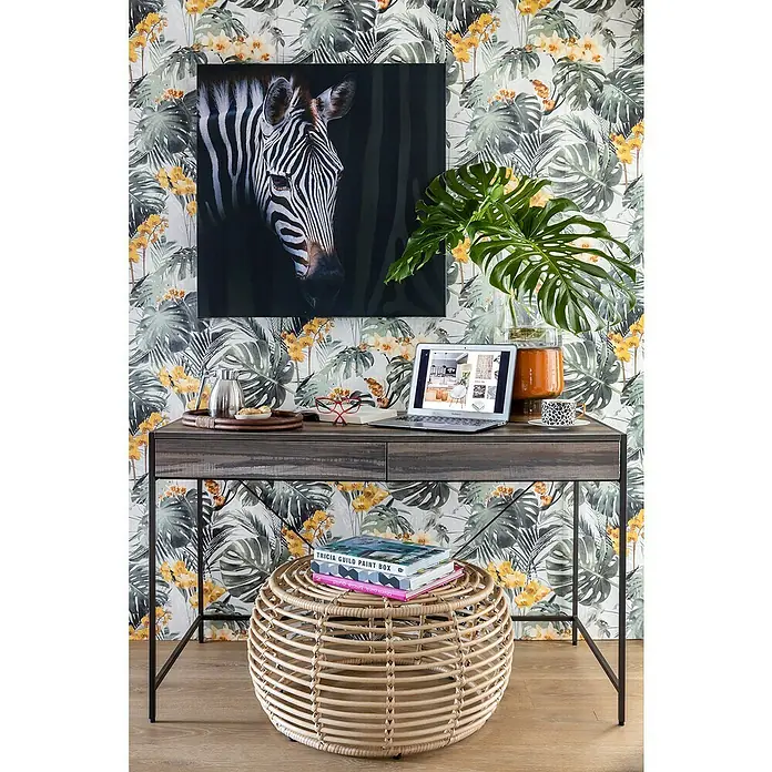 Mesa de escritorio Kala - L x An x Al: 60 x 123 x 76 cm, Número de cajones: 2 ud., Marrón/Negro - Espacio de trabajo moderno con escritorio de madera oscura, taburete de ratán, computadora portátil y arte de cebra, que muestra una elegante oficina en casa.