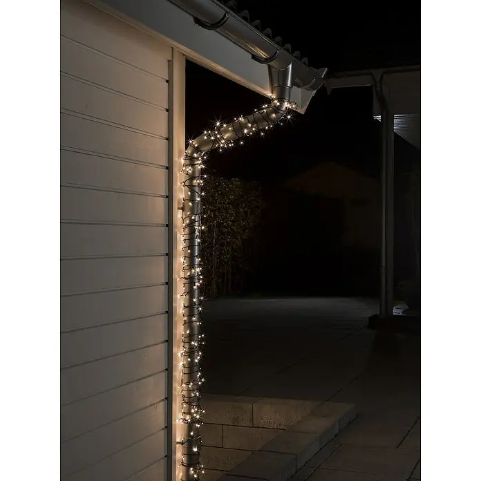 Konstsmide LED-Lichterkette - Außen, Lichtfarbe: Bernstein, Anzahl Leuchtmittel: 500 Stk., Netzbetrieben, 34,93 m - Bild einer Regenrinne mit warmweißen Lichterketten umwickelt, die eine gemütliche Atmosphäre erzeugen. Perfekt für eine stimmungsvolle Außenbeleuchtung.