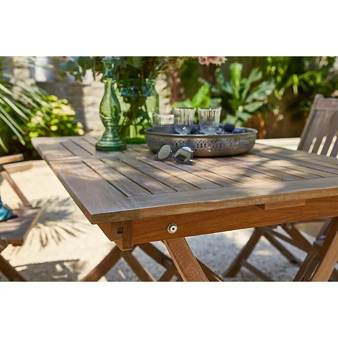 Sunfun Gartenmöbel-Set - 5 -tlg., Akazie, White washed - Nahaufnahme des Teakholztisches im Freien, der eine stilvolle und einladende Gartenszene schafft.