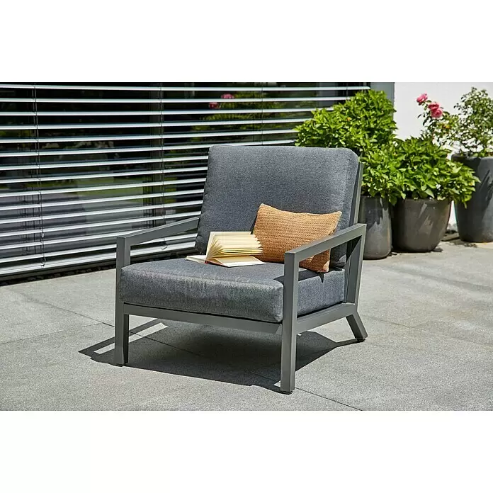 Sunfun Maja Sillón de exterior - An x Pr x Al: 85 x 76,5 x 76,5 cm, Aluminio/Poliéster, Antracita - Sillón de exterior gris con cojines gris oscuro, un libro y un cojín trenzado en un patio.