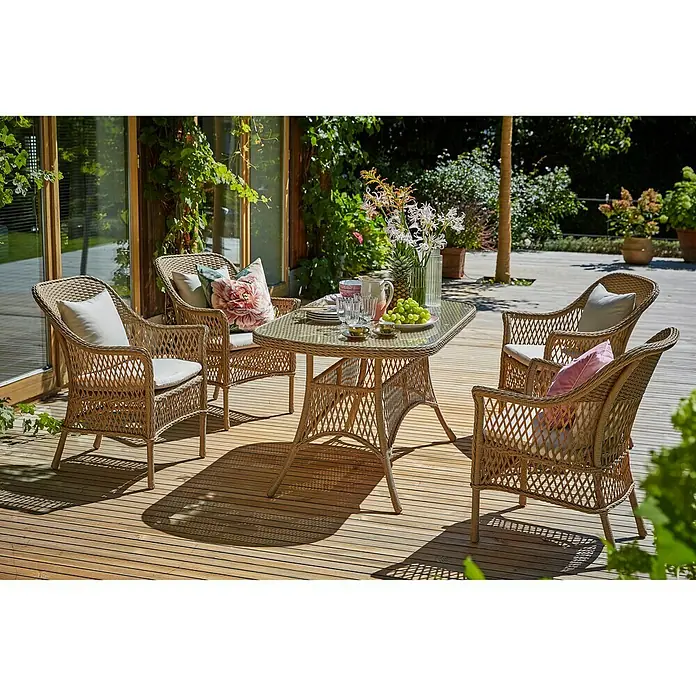 Sunfun Mesa de jardín Sophie - L x An x Al: 140 x 80 x 72 cm, Aluminio, Beige - Una mesa de jardín con cuatro sillas de mimbre y cojines cómodos, ideal para relajarse al aire libre, sobre una terraza de madera.