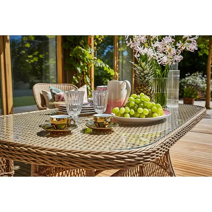 Sunfun Mesa de jardín Sophie - L x An x Al: 140 x 80 x 72 cm, Aluminio, Beige - Una mesa puesta con tazas doradas, vasos, una jarra, una piña y un bol de uvas verdes sobre una mesa de ratán.