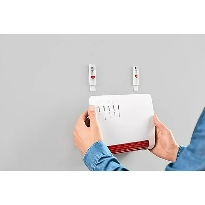Tesa Clavo adhesivo - Carga soportada: 0,5 kg, 2 ud., Paredes pintadas, Blanco - Router Wi-Fi montado en un soporte de pared. El dispositivo es blanco con un acento rojo.