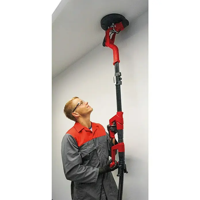 Einhell Wand- & Deckenschleifer TC-DW 225 - 600 W, Durchmesser Schleifscheibe: 225 mm - Ein Mann schleift mit einer Langhalsschleifmaschine eine Decke, um die Oberfläche zu glätten. Professionelles Werkzeug für Renovierungsarbeiten.