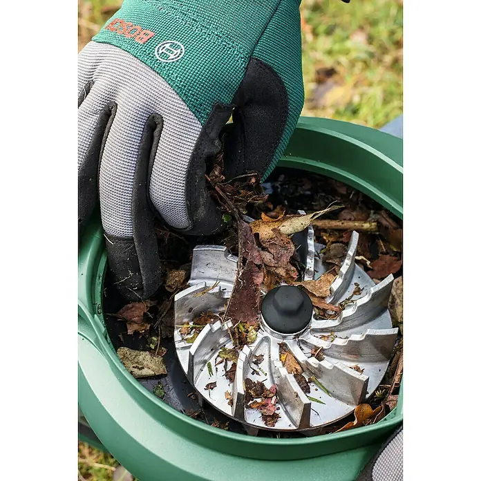 Bosch Elektro-Laubsauger UniversalGardenTidy 2300 - 2.300 W, Blasgeschwindigkeit: 165 km/h - 285 km/h - Detailaufnahme eines Bosch Gartenhäckslers in Benutzung mit einer Hand, die Laub hineingibt.