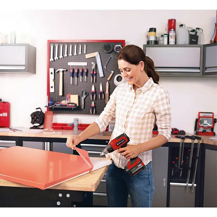 Einhell Power X-Change 18V Akku-Heißluftgebläse TE-HA 18 Li-Solo - Ohne Akku, 18 V, Temperaturbereich: 350 °C - 550 °C - Frau arbeitet mit einer Einhell Heißluftpistole in ihrer Werkstatt, um eine Oberfläche zu bearbeiten.