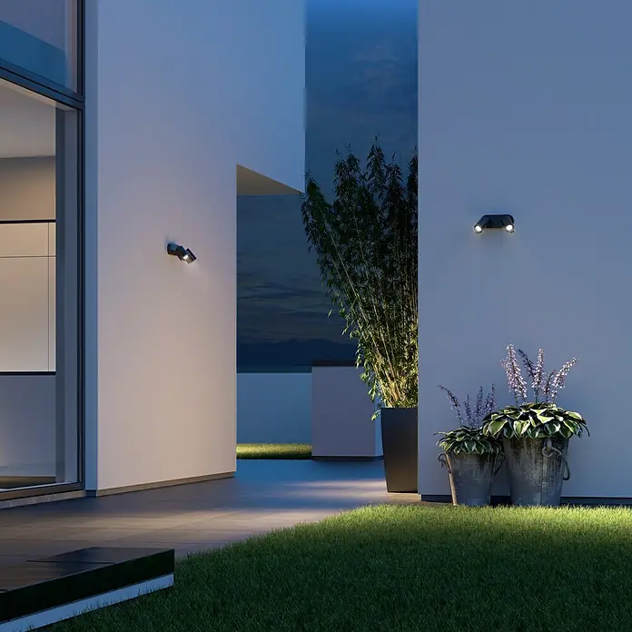 Steinel LED-Sensor-Außenwandleuchte Spot Duo S anthrazit - 14,95 W, L x B x H: 9,8 x 24,7 x 17,5 cm, Anthrazit, Warmweiß - Wandleuchten erhellen eine moderne Terrasse mit Pflanzen und Rasen.