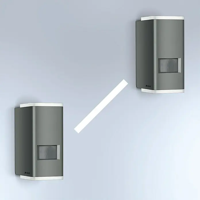 Steinel LED-Außenwandleuchte L 930 S anthrazit - 9,3 W, 92 x 63 x 137 mm, IP44 - Zwei moderne Steinel-Bewegungsmelder in Grau und Weiß an einer Wand. Präzise Erfassung für Innen- und Außenbereiche.