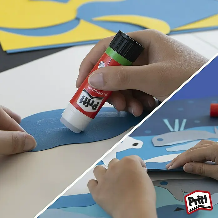 Pritt Klebestift - 22 g, Fest - Ein Kind benutzt einen Pritt Klebestift, um blaue Papierstücke auf eine Bastelarbeit zu kleben. Basteln mit Pritt Klebestift für Kinder.