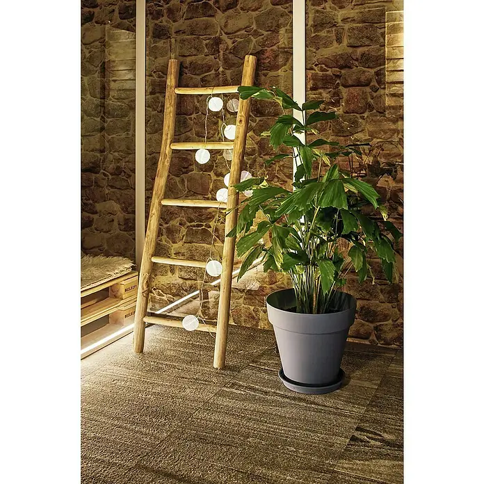 Paulmann Guirnalda luminosa LED Lampion - 3,6 m, Para exterior - Escalera decorativa de madera con luces y una planta de interior en una maceta gris, sobre pared de piedra rústica.