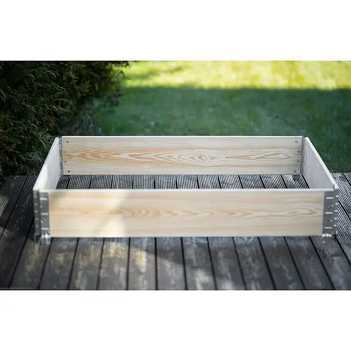 Gardol Hochbeetumrandung PalettenrahmenL x B x H: 120 x 80 x 20 cm, Holz, Natur - Nahaufnahme eines hellen, unbehandelten Hochbeets aus Holz mit metallverstärkten Ecken auf einer Holzterrasse.