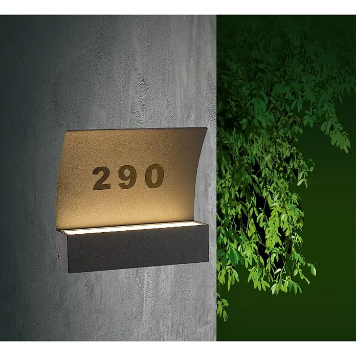 Starlux LED-Außenwandleuchte Numero - 8 W, 22 x 5,3 x 19,6 cm, Dunkelgrau, IP65 - Moderne Hausnummernleuchte mit der Nummer 290 an einer grauen Wand, beleuchtet und mit Pflanzen im Hintergrund.