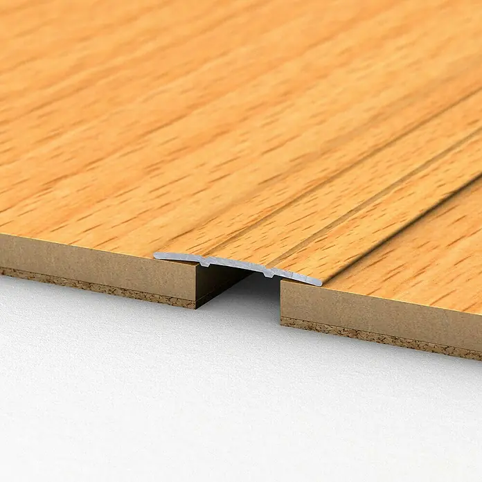LOGOCLIC Übergangsprofil 132 - Buche, 1 m x 38 mm x 2,5 mm, Montageart: Kleben - Ein Detailansicht einer Bodenübergangsleiste zwischen zwei Holzböden. Die Leiste ist aus Metall und überbrückt den Spalt.
