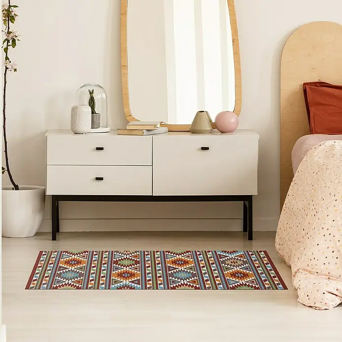 Alfombra de vinilo Croma Kilim - Multicolor, 75 x 45 cm - Una alfombra de pasillo colorida con un estampado étnico se encuentra frente a una cómoda blanca, dando un toque acogedor a la habitación.