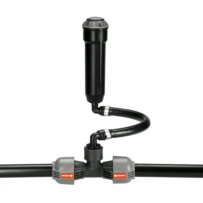 Gardena Sprinklersystem Regneranschluss - ¾″/½″ - Das Bild zeigt einen Gardena Wasserfilter mit schwarzem Gehäuse, verbunden durch einen Schlauch mit einem T-Stück auf schwarzem Hintergrund.